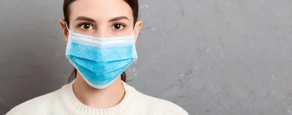 시멘트 배경에 의료용 마스크를 여성의 건강을 보호하 십시오 코로나 바이러스 — 스톡 사진