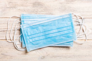 Ahşap arka plandaki koruyucu tıbbi maskelerden oluşan salgın geçmişi. Dünya karantina kavramı.