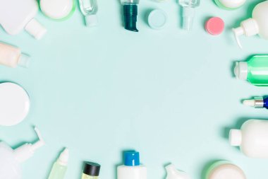 Çerçeve plastik vücut bakım şişesi Düz tasarım için mavi arka plan boş alan kozmetik ürünleri ile kompozisyon yatıyordu. Beyaz Kozmetik kapları seti, fotokopi alanı ile üst görünüm.