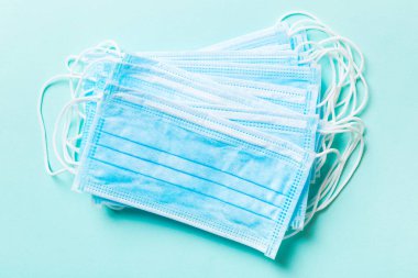 Mavi arka plandaki tıbbi maske yığınını kapatın. Wuhan virüsü. Dünya salgını.