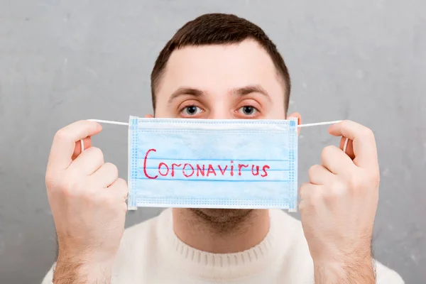 Retrato Joven Enfermo Sosteniendo Una Máscara Médica Con Palabra Coronavirus — Foto de Stock