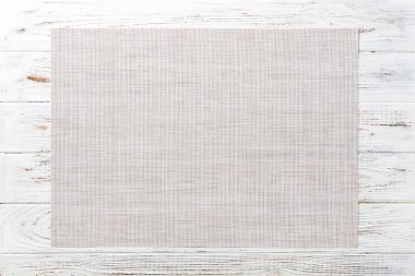 Tahta zemin üzerinde boş beyaz masa örtüsünün fotokopi alanı ile üst görünümü.