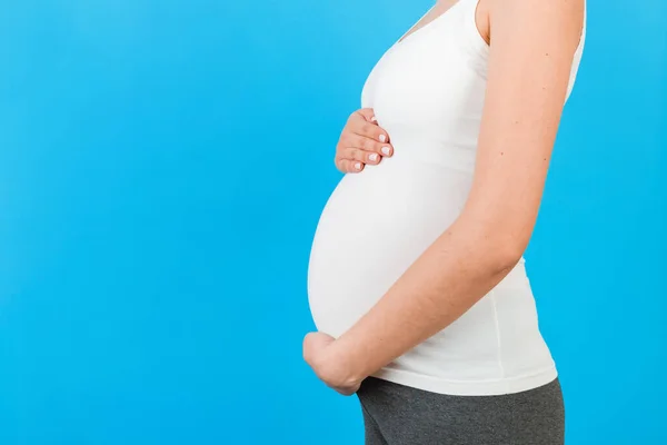 Großaufnahme Einer Schwangeren Frau Heimkleidung Die Ihren Bauch Vor Blauem — Stockfoto