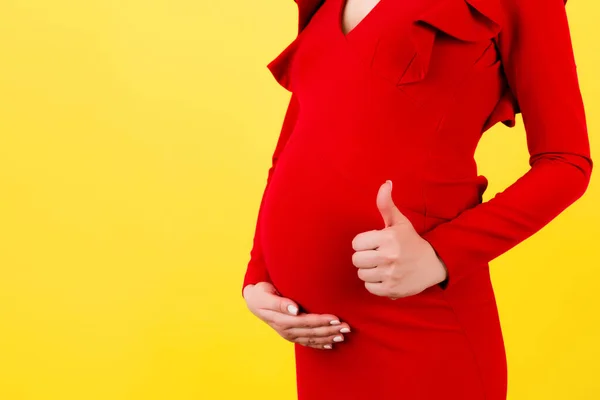 Ujęcie Pozytywnej Kobiety Ciąży Czerwonej Sukience Pokazujące Chłodny Gest Nad — Zdjęcie stockowe
