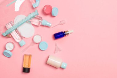 Pembe arka plan üzerinde seyahat boyutu kozmetik şişe seti. Krem kavanoz düz yatıyordu. Vücut bakımı tarzı kavramının en iyi görünümü.