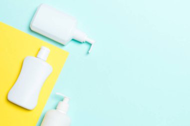 Beyaz Kozmetik kaplar seti sarı ve mavi arka planda izole edilmiş, fotokopi alanı olan üst manzara. Senin için bir grup plastik kaplar ve boş bir yer tasarladın..