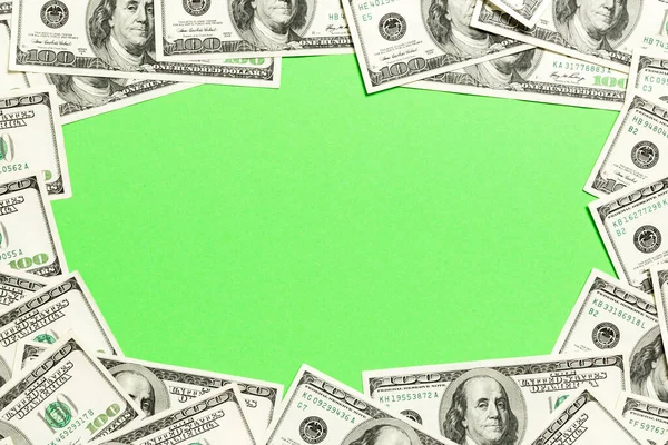 Frame of one hundred dollar bills with empty space for your design. Top view of business concept on green background with copy space.