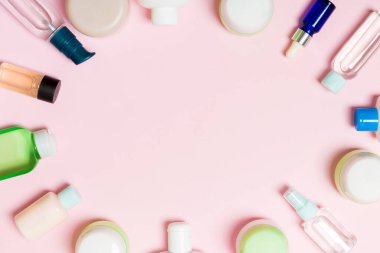 Çerçeve plastik vücut bakım şişesi Düz tasarım için pembe arka plan boş alan kozmetik ürünleri ile kompozisyon yatıyordu. Beyaz Kozmetik kapları seti, fotokopi alanı ile üst görünüm.