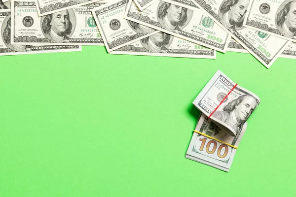 American money on colored background top view, with empty place for your text business money concept. One hundred dollar bills with stack of cash.
