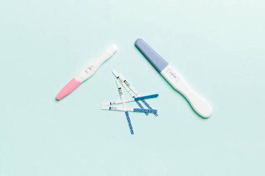 Renkli arkaplan üzerinde renkli hamilelik testi, kopya alanı ile üst görünüm.