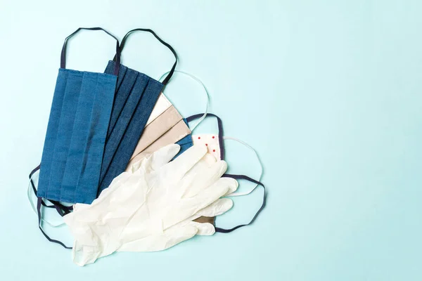 青い背景に自家製の綿マスクとニトリル手袋のヒープのトップビュー コピースペース付きの個人保護コンセプト — ストック写真