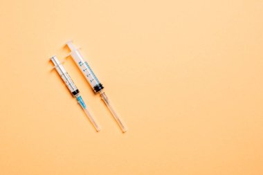 Renkli arka planda tıbbi şırıngaların üst görüntüsü. Fotokopi alanı ile sağlık hizmeti kavramı.