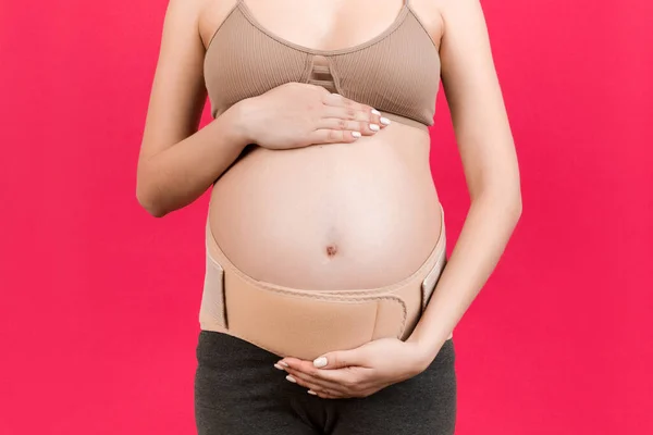 Pembe Arka Plandaki Hamile Bir Kadının Destekleyici Bandajının Fotokopi Alanı — Stok fotoğraf