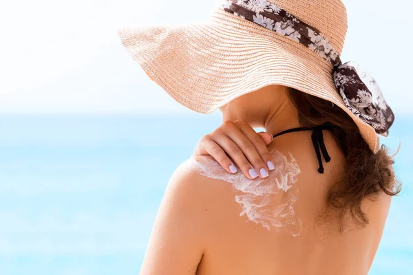 Hermosa Mujer Con Sombrero Está Poniendo Crema Solar Hombro Playa — Foto de Stock