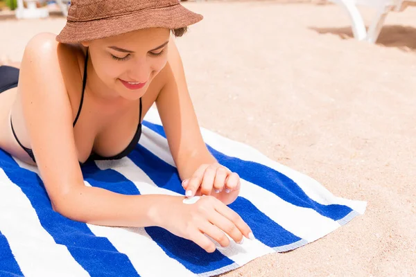 Dziewczyna Jest Relaks Ręcznik Piasku Plaży Stosując Balsam Opalania Rękę — Zdjęcie stockowe