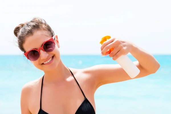 Young Woman Holding Bottle Sunblock Body Sea Background — Stock Photo, Image