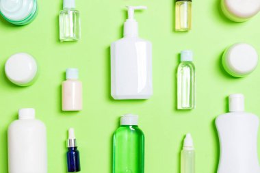 Plastik vücut bakımı şişesi grubu düz tasarım için yeşil arka plan boş alan kozmetik ürünleri ile kompozisyon yatıyordu. Beyaz Kozmetik Konteynerler, kopya alanı ile üst görünüm seti.