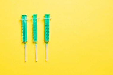 Renkli arkaplanda fotokopi alanı olan tıbbi enjeksiyon için üst sıradaki şırıngaların görüntüsü. Sağlık ve aşı kavramı.