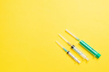 Renkli arka planda fotokopi alanı olan tıbbi şırıngaların üst görüntüsü. Enjeksiyon ekipmanı konsepti.