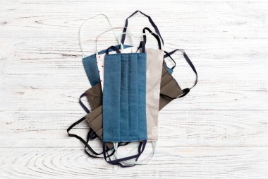 Beyaz ahşap arka planda yeniden kullanılabilir ev yapımı pamuk yığınının üst görüntüsü. Kopya alanı ile solunum koruma kavramı.