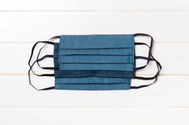 Ahşap arka planda yeniden kullanılabilir ev yapımı tekstil maskelerinin üst görüntüsü. Fotokopi alanı ile solunum koruma kavramı. DIY kavramı.