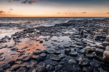 Güneşin doğduğu günün güzel manzarası dalgalar Giant 's Causeway Kuzey İrlanda Ni