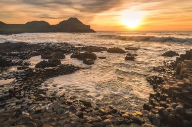 Güneşin doğduğu günün güzel manzarası dalgalar Giant 's Causeway Kuzey İrlanda Ni