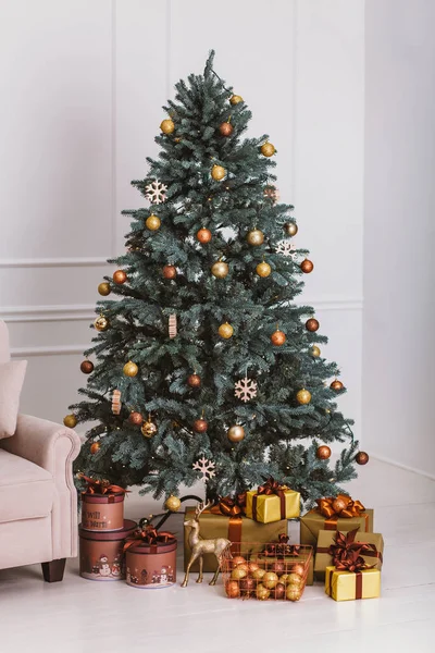 Árbol de Navidad con decoraciones y regalos. Ambiente acogedor de Navidad. La reunión del nuevo año en casa. Elegante interior de la habitación con árbol de Navidad decorado . Imagen de stock