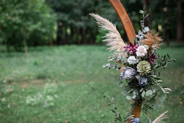 Arco redondo de casamento em estilo rústico decorado com uma composição de flores frescas para uma cerimônia de casamento ao ar livre. Decoração rústica na moda . — Fotografia de Stock