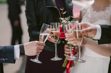 Kutlama. Şampanya kadehlerini tutan eller ve kadeh kaldıran şarap. Parti, düğün, kutlama, alkol, yaşam tarzı, arkadaşlık, tatil, Noel, yeni yıl ve tıkırtı konsepti.