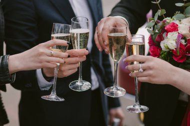 Kutlama. Şampanya kadehlerini tutan eller ve kadeh kaldıran şarap. Parti, düğün, kutlama, alkol, yaşam tarzı, arkadaşlık, tatil, Noel, yeni yıl ve tıkırtı konsepti.