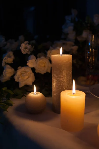 Rosa branca e velas ardentes em uma mesa no escuro, decoração de uma mesa festiva do jantar, espaço do texto . — Fotografia de Stock