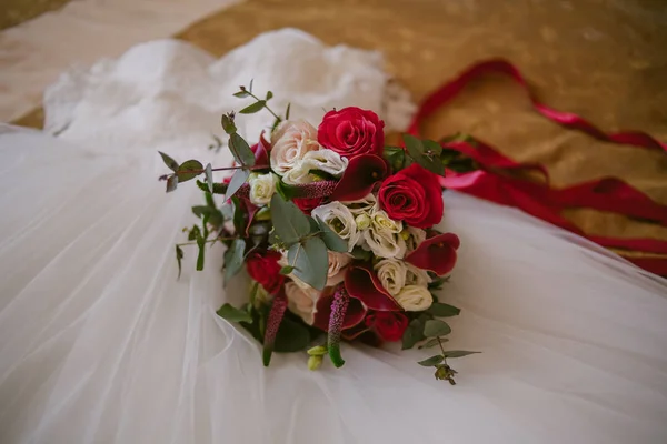 Beau bouquet de mariage repose sur une robe de mariée. Jour du mariage. Préparation de mariage . — Photo