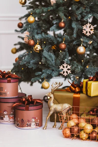 Caja de regalo de Navidad con decoraciones cerca del árbol de Año Nuevo. El amor nos mantendrá calientes. Elegante interior de la habitación con árbol de Navidad decorado . Fotos de stock