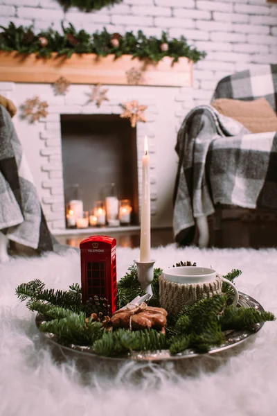 Une tasse de tisane chaude sur un plateau de fer décoré de branches d'arbres de Noël, de bougies allumées, de cônes, de biscuits, de jouets. Fond de Noël. Nouvel An humeur . — Photo