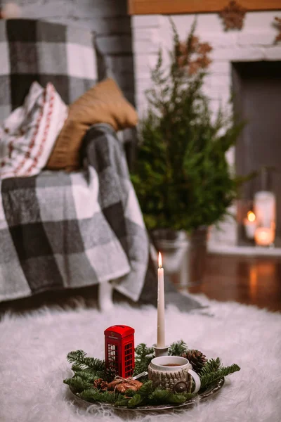 Une tasse de tisane chaude sur un plateau de fer décoré de branches d'arbres de Noël, de bougies allumées, de cônes, de biscuits, de jouets. Fond de Noël. Nouvel An humeur . — Photo