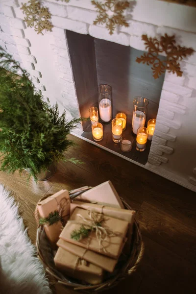 Boîtes avec cadeaux, près du sapin de Noël et cheminée décorée avec des bougies.. . — Photo