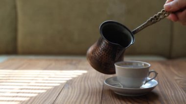 Barista bir fincana kahve doldurur. Bir fincan dumanı tüten Türk kahvesi. Kahve molası.