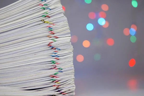 Stack of paperwork have colorful bokeh circle as background