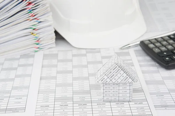 House with blur white engineer hat and pile overload document