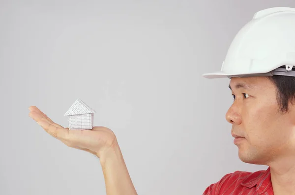 Engenheiro usar camisa vermelha e chapéu branco olhando para casa — Fotografia de Stock
