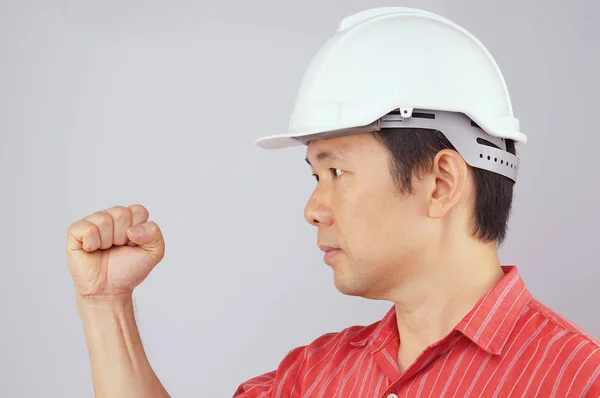 Inżynier nosić czerwoną koszulę i biały kapelusz zrobić sygnału pięść — Zdjęcie stockowe