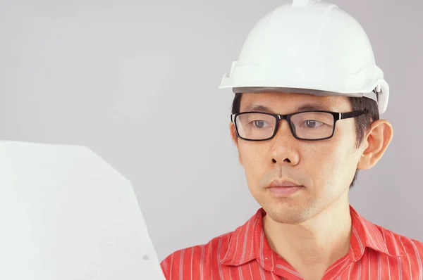 Engenheiro desgaste camisa vermelha está olhando para o documento fundo branco — Fotografia de Stock