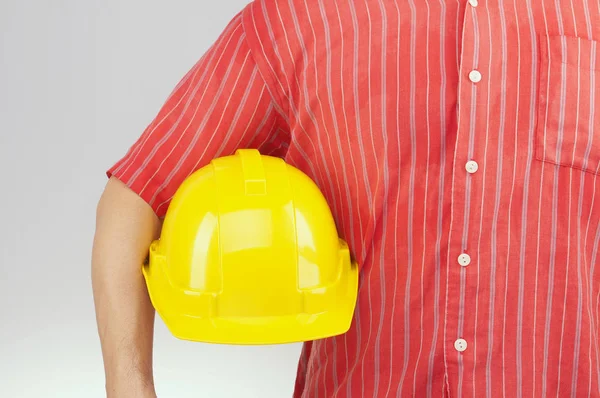 Engenheiro com camisa vermelha segurar chapéu amarelo no fundo branco — Fotografia de Stock