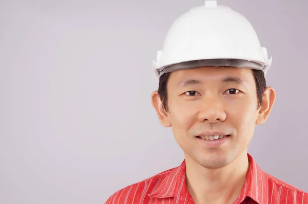快乐的工程师穿红色衬衫和帽子看起来到前面 — 图库照片