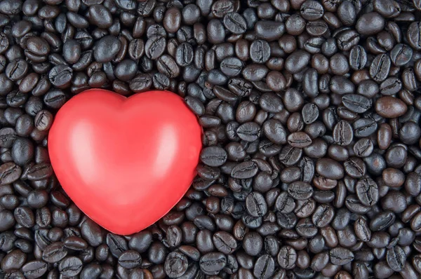 Red heart shape place on black roasted coffee beans — Stock Photo, Image