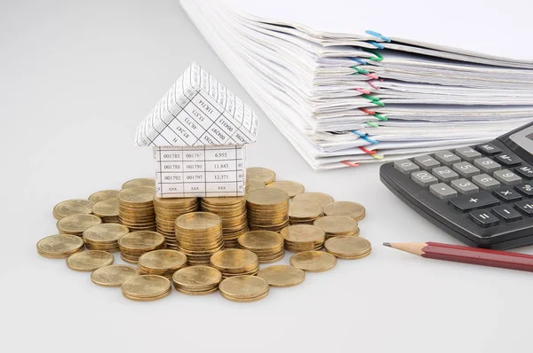 Haus auf Stapel Goldmünzen mit Bleistift und Taschenrechner — Stockfoto