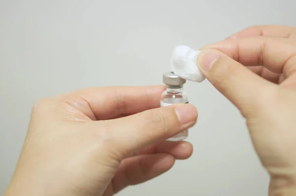 Nurse is cleansing vial vaccine by cotton ball with alcohol — Stock Photo, Image