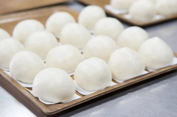 Kahverengi ahşap tepsideki kağıt buğulanmış çörek kapatın
