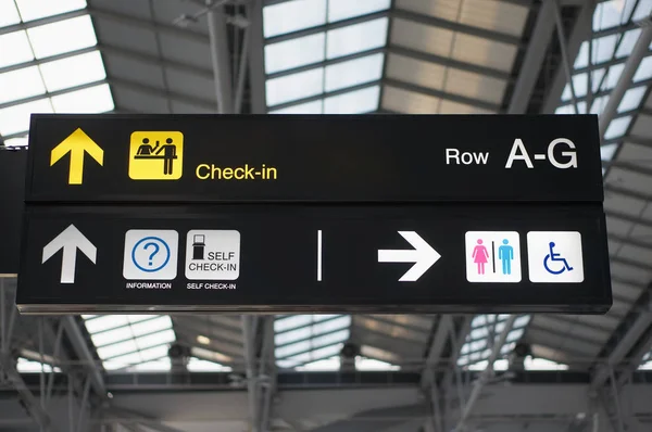 Self check-in and toilets board sign at international airport Stock Photo